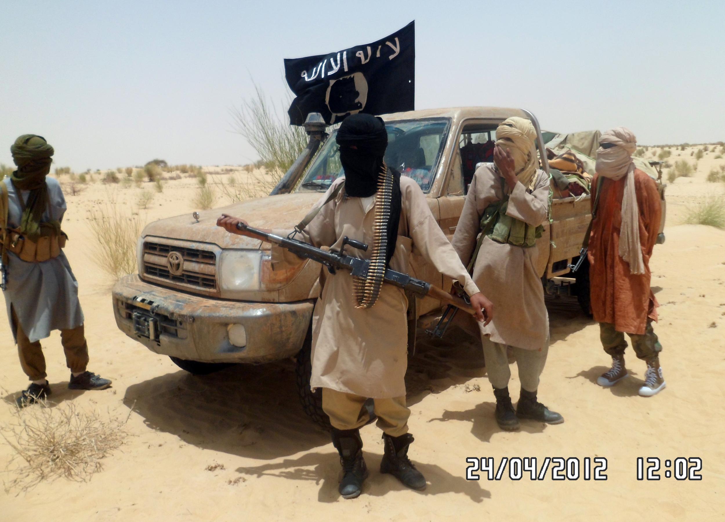 Ansar Dine Islamist rebels next to a banner that reads ‘There is no god but god’ during the release of a Swiss hostage in then-rebel held northern Mali in 2012