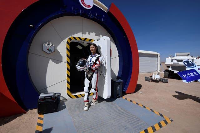 A guide wearing a space suit stands at an entrance at "Mars Base 1", a C-Space Project, in the Gobi desert, some 40 kilometres from Jinchang in China's northwest Gansu province on April 17, 2019