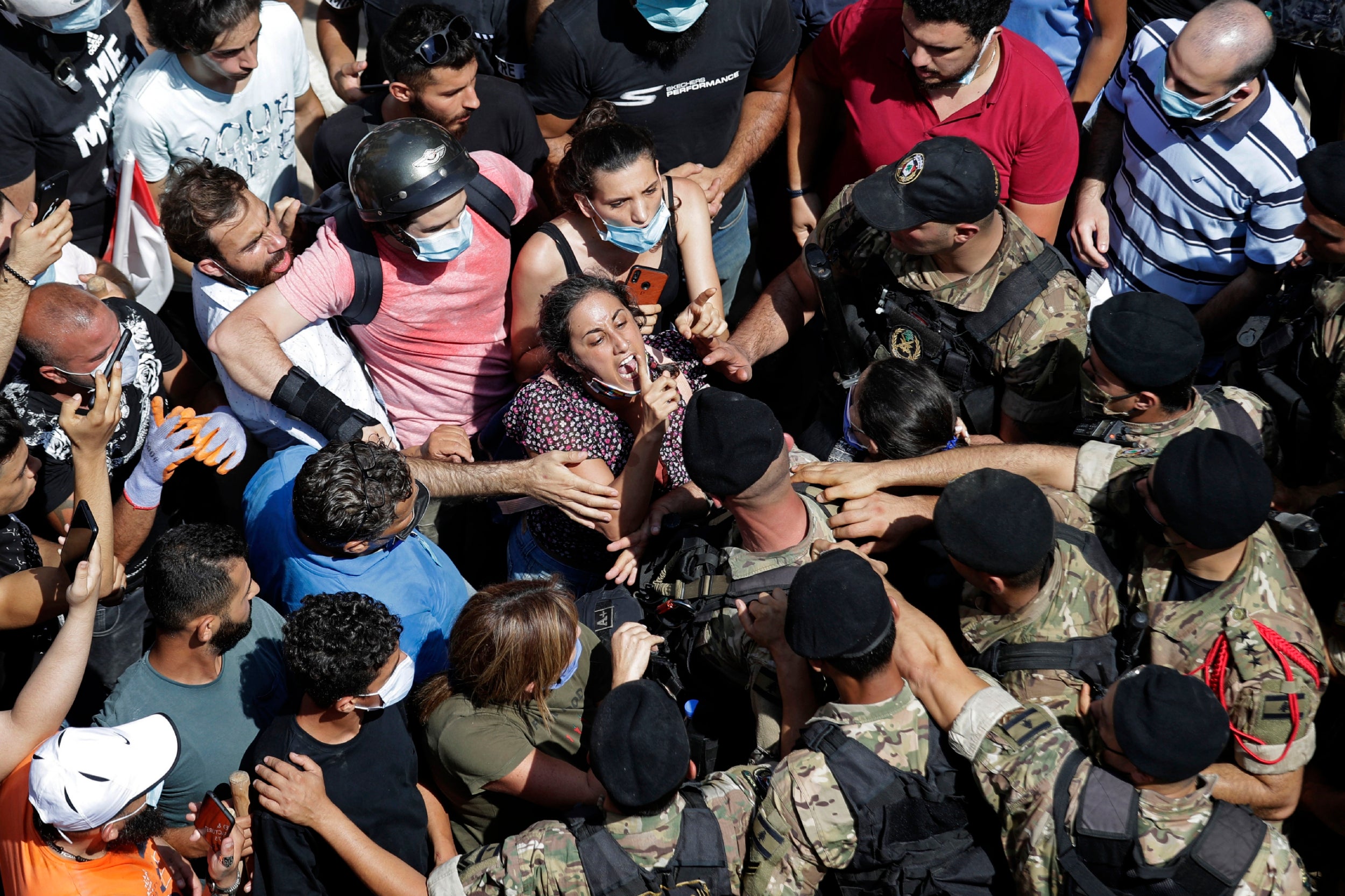 A woman yells during scuffles with soldiers blocking a Beirut road as French president Emmanuel Macron visits the Gemmayzeh neighbourhood