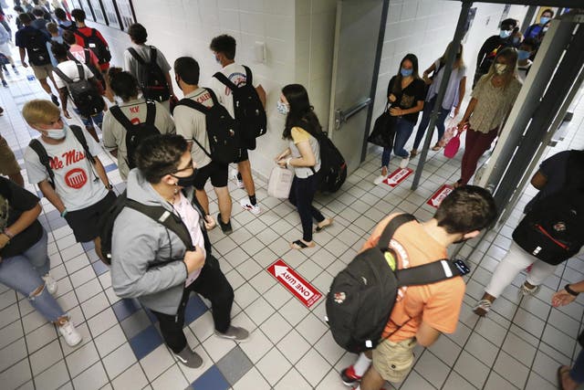 Students at Corinth High School follow the directional signage posted on the floor and keep foot traffic moving in the proper direction as they change classes on the first day back to school Monday 27 July 2020