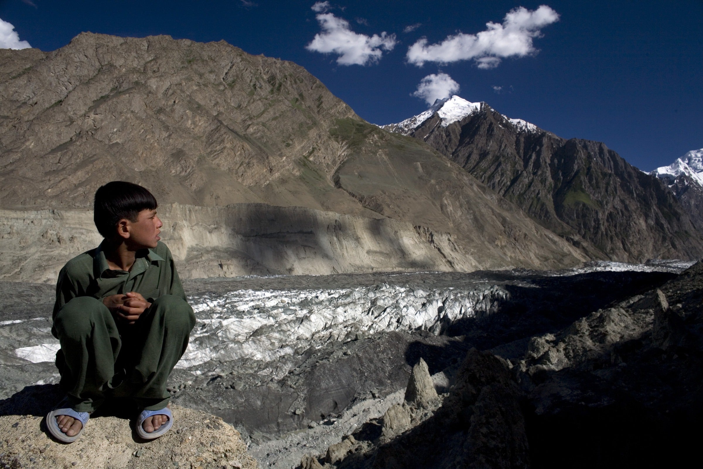 A boy looks at the Hopar glacier in the Central Hunza Region, Pakistan. At the present rate of climate change, a significant proportion of the Himalayan glaciers, the primary source of water for the country, could be lost within decades