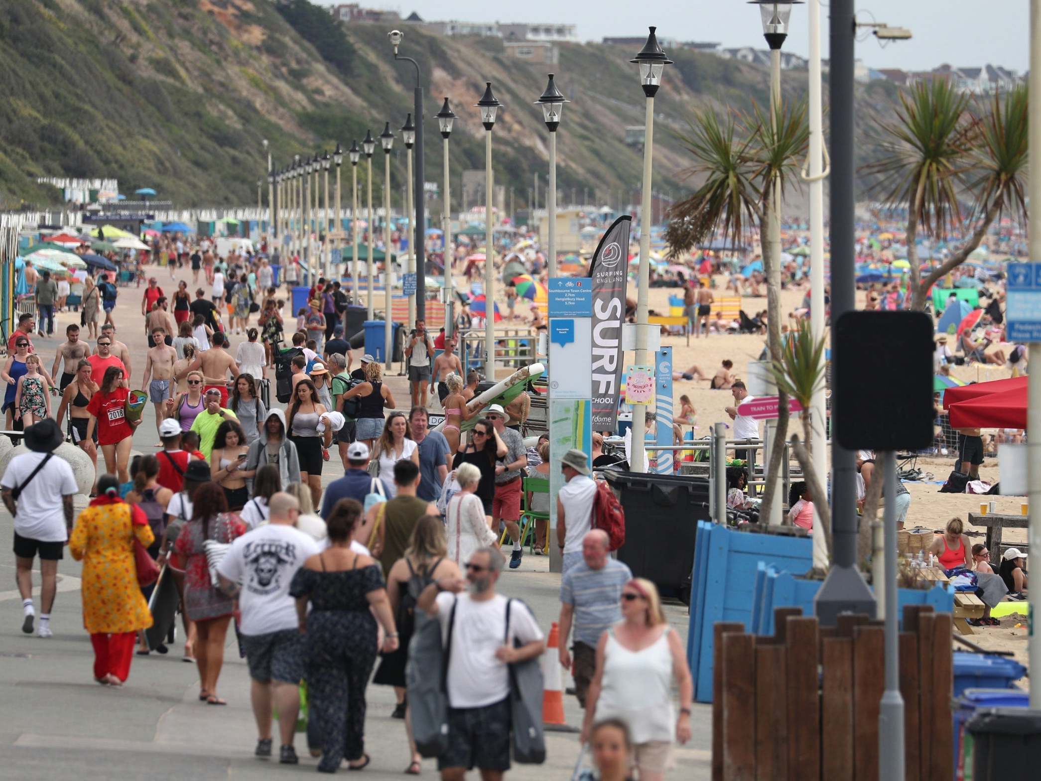 People walk along the beach front on Boscombe beach in Dorset