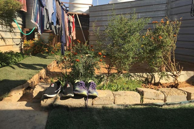 Shoes are left outside in a small garden in a refugee camp in Jordan