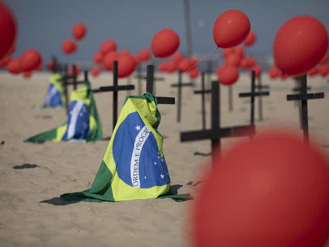 Crosses, red balloons and Brazilian nation flags are placed in the sand on Copacabana beach in a demonstration organised by Rio de Paz