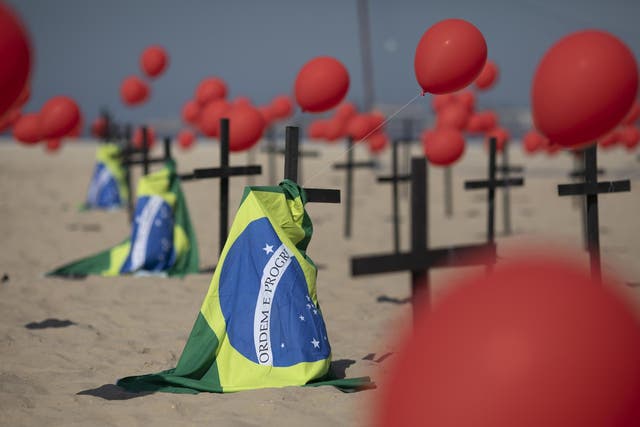 Crosses, red balloons and Brazilian nation flags are placed in the sand on Copacabana beach in a demonstration organised by Rio de Paz