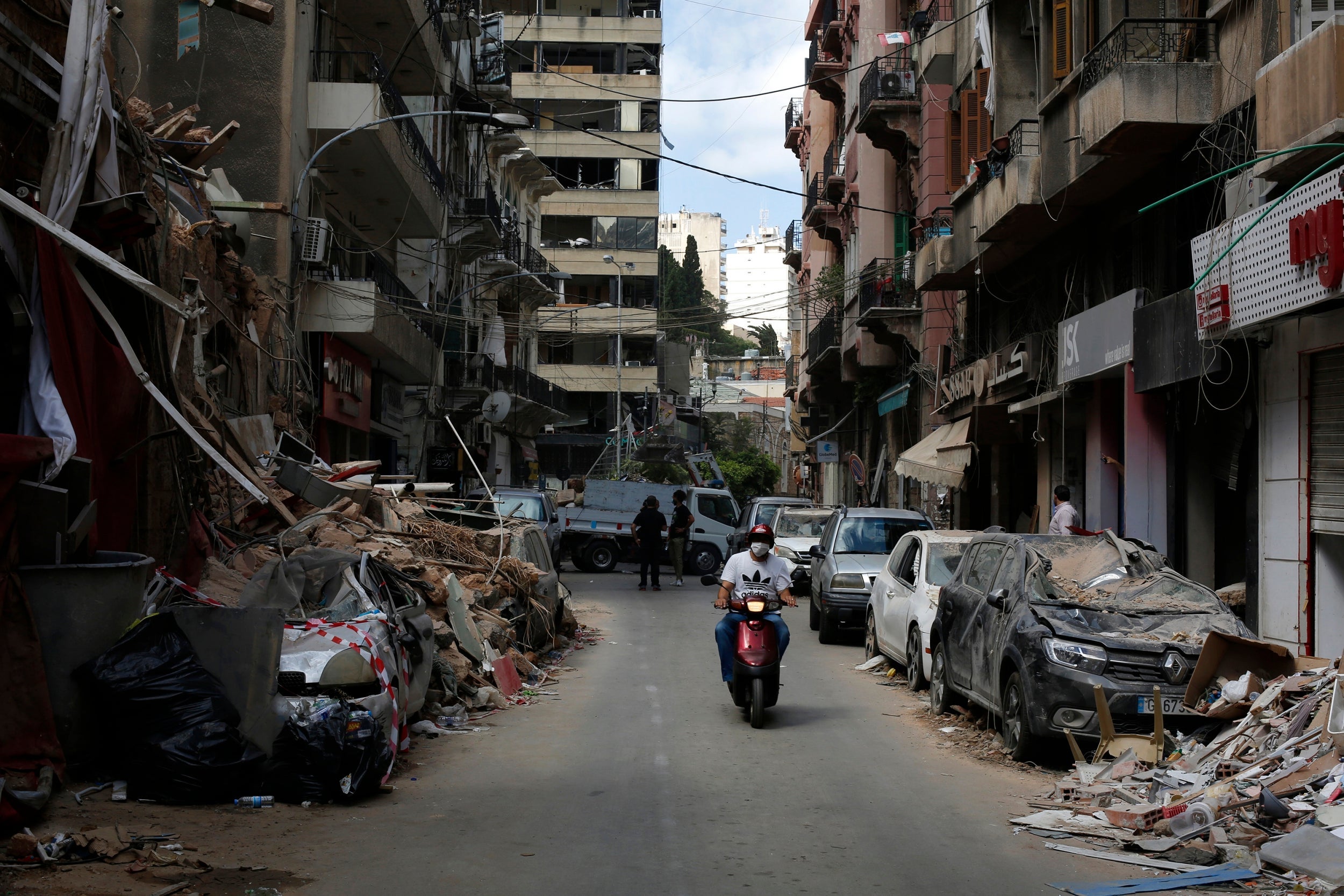 A man rides past damaged buildings at a neighbourhood near the explosion