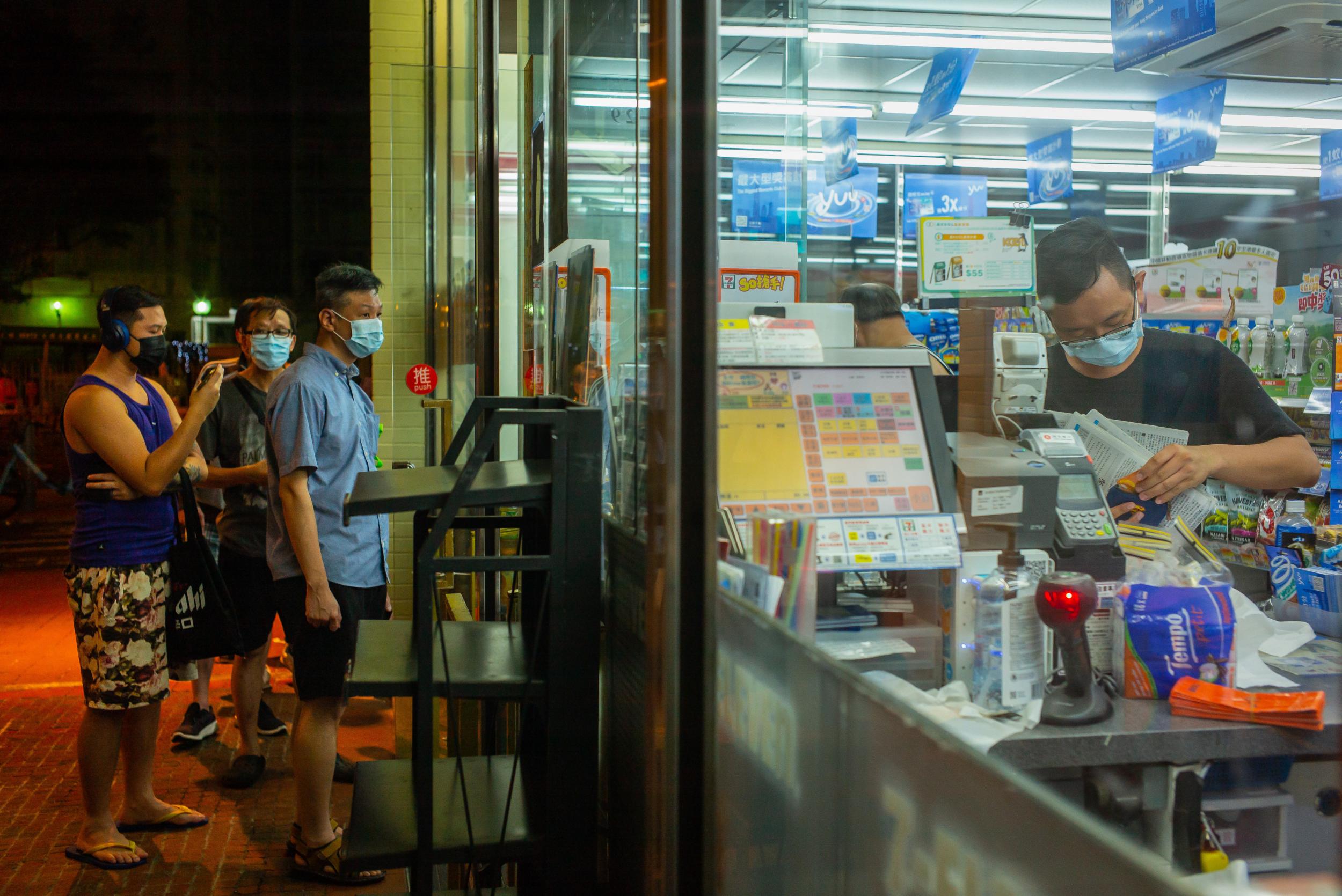 Hong Kongers queue outside a shop selling Apple Daily in the early hours of Tuesday morning