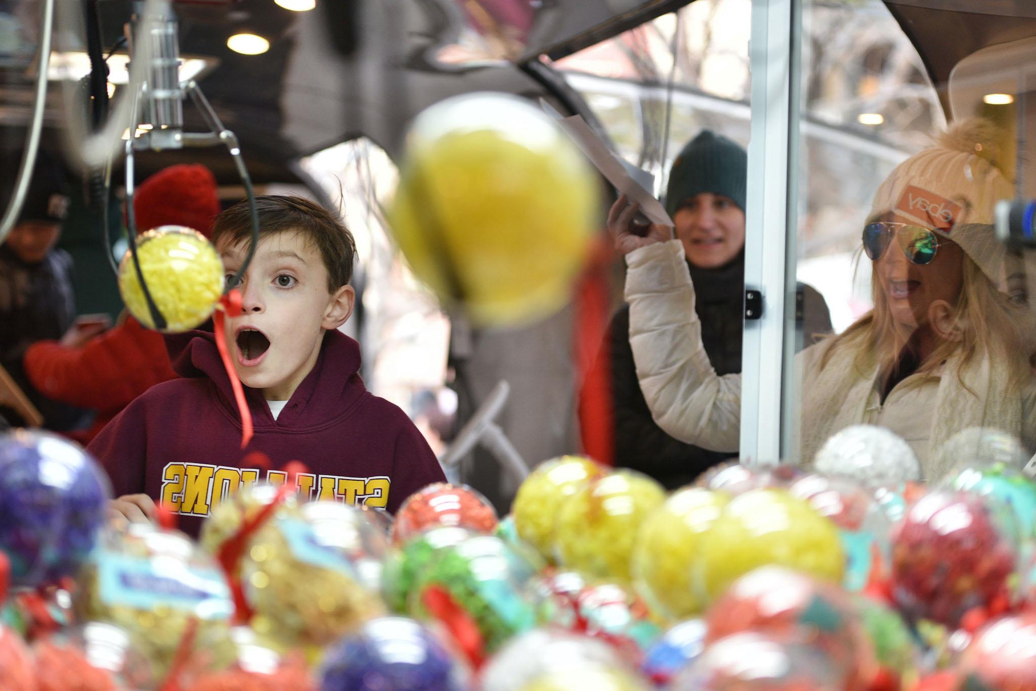 Aden Foster of Colorado Springs wins a prize on the ebay claw machine as Codie Murphy cheers him on at the 'Did You Check eBay?' Holiday Airstream at Christkindl Market on December 4, 2017 in Denver, Colorado