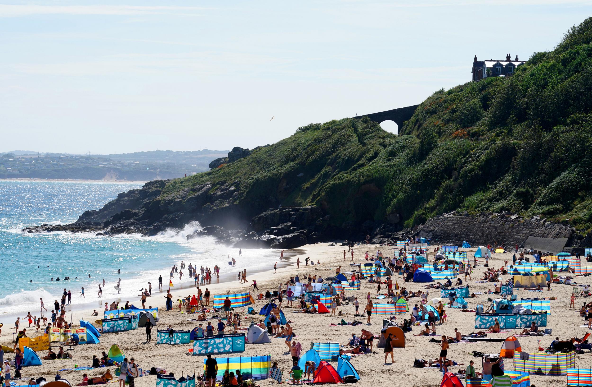 Groups of people relax on the beach in the sun on August 9, 2020 in St Ives, Cornwall, England