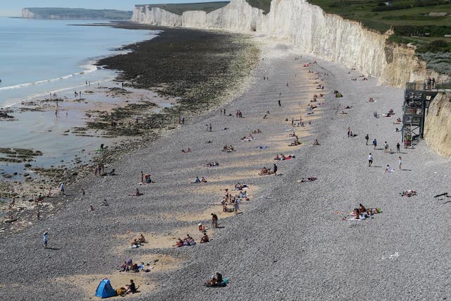 People enjoy the good weather on a beach near Eastbourne, Sussex, on 20 May, 2020.