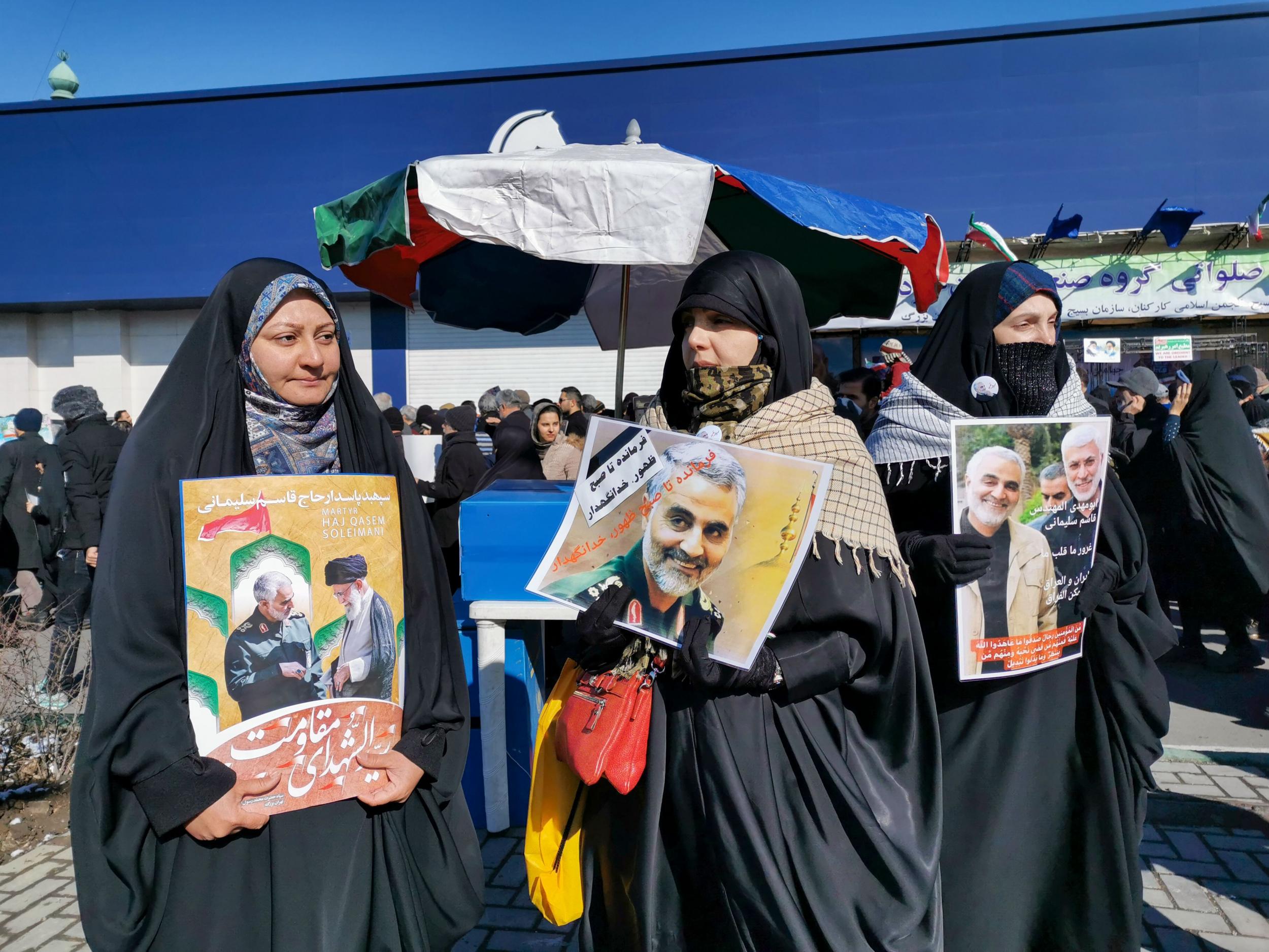 Women carry portraits of slain general Qasem Soleimani, killed in a US drone strike, during commemorations for the Islamic Revolution