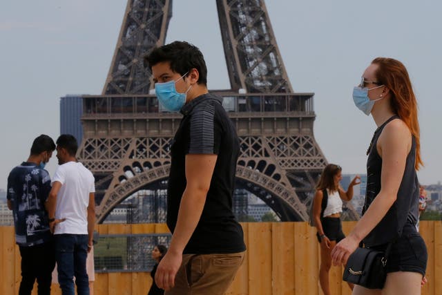 People wearing masks to prevent the spread of COVID-19 walk at Trocadero plaza near Eiffel Tower in Paris