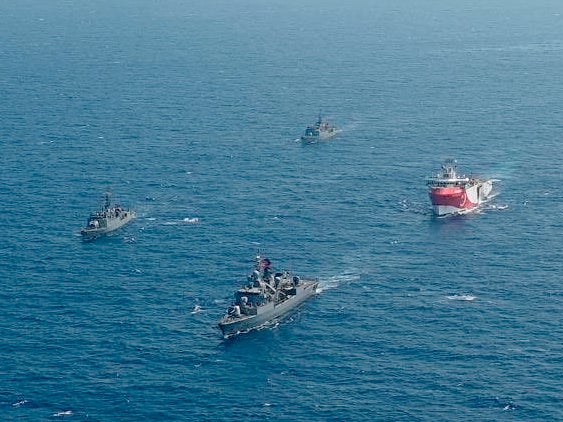 Turkey's research vessel, Oruc Reis, right, is surrounded by Turkish navy vessels west of Antalya in the Mediterranean