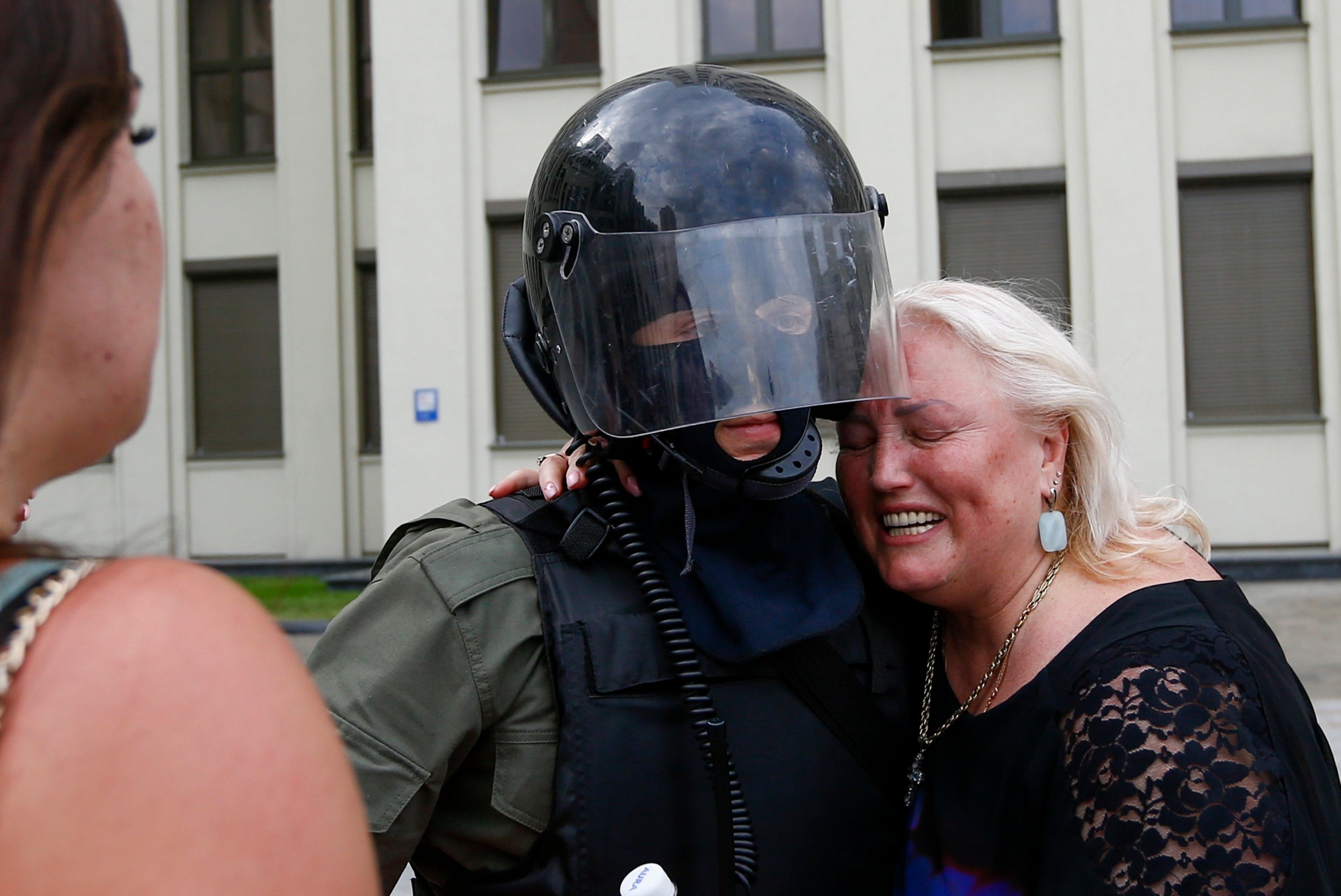 A woman breaks down as she embraces a soldier guarding the Belarusian government building in Minsk on 14 August 2020