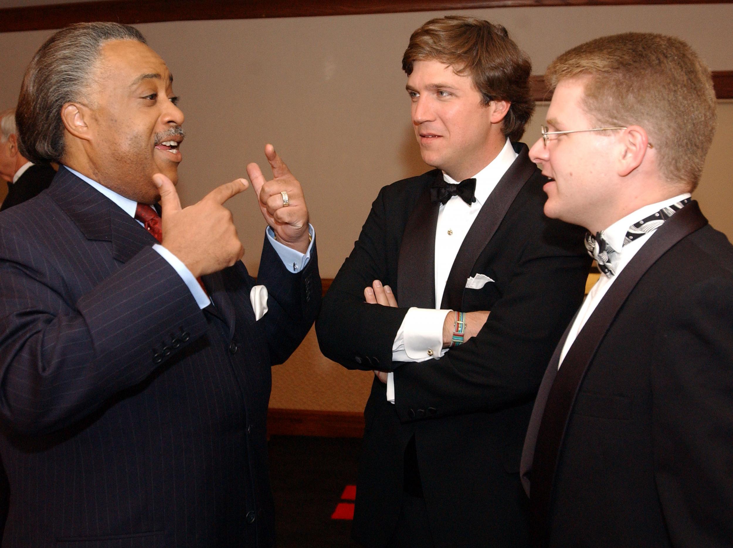 Carlson, during his time as the host of CNN Crossfire, speaks to Reverend Al Sharpton, the then Democratic presidential candidate (Getty)