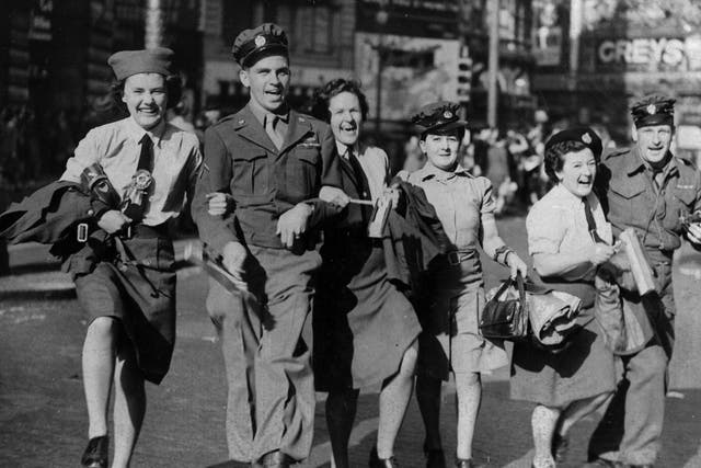 WAAFs link arms with soldiers during the VJ Day celebrations in Piccadilly Circus, 10 August 1945