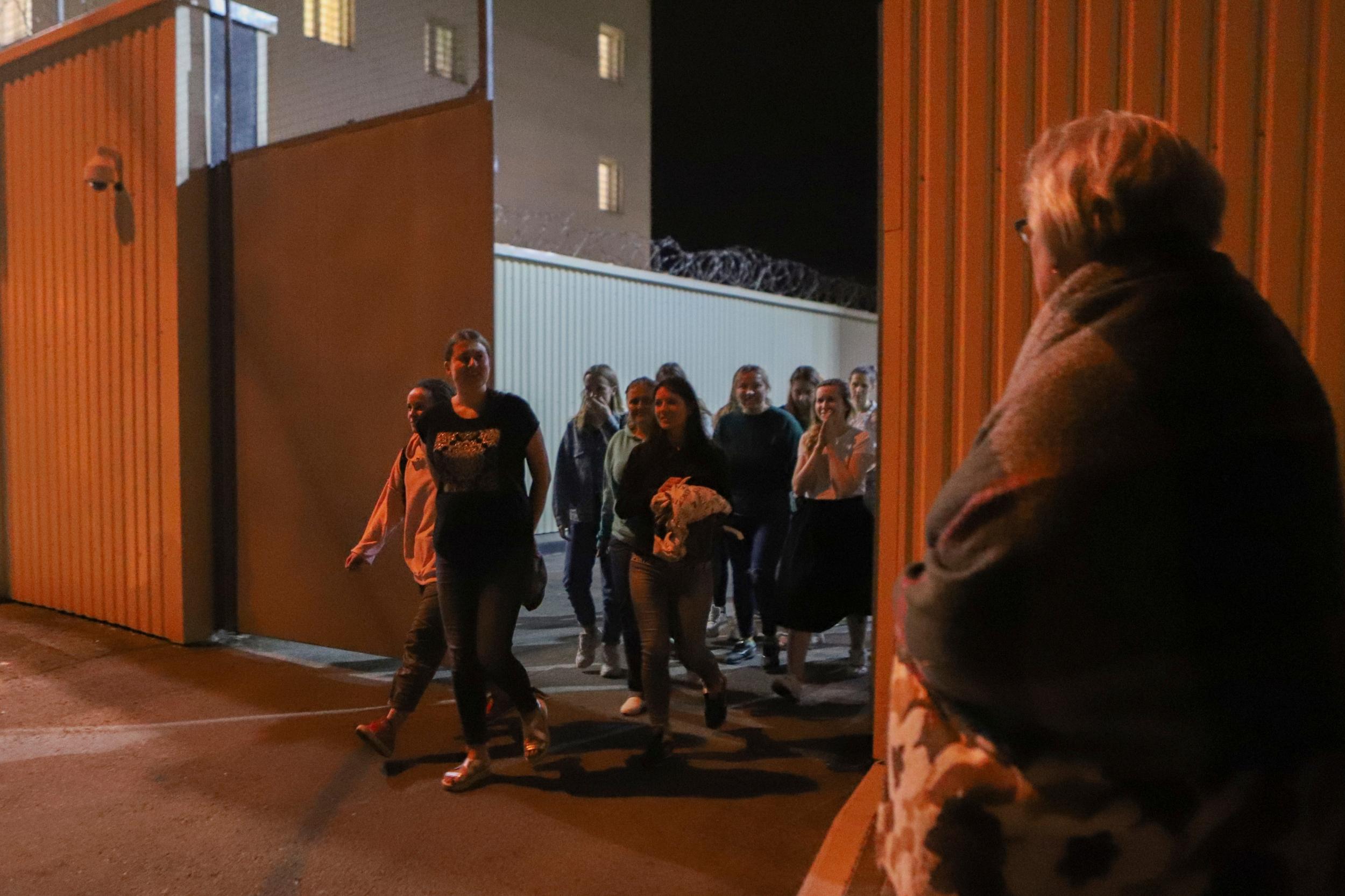 Women walk through a gate after being released from a detention centre where they were detained following protests