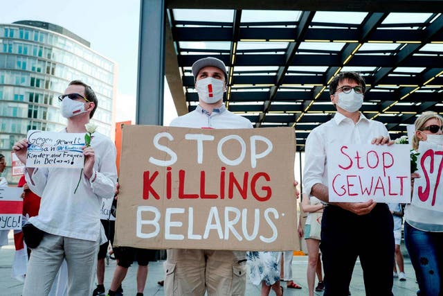 A protester holds a sign reading "Stop Killing Belarus" during a demonstration on the contested elections in Belarus