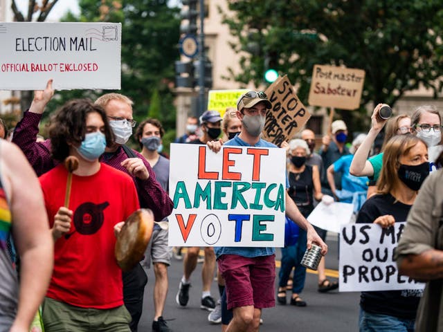 Protesters march to the apartment of Postmaster General Louis DeJoy in DC on 15 August. President Trump acknowledged he is blocking funds for the US Postal Service to make it more difficult for the agency to handle mail-in ballots for November's presidential election