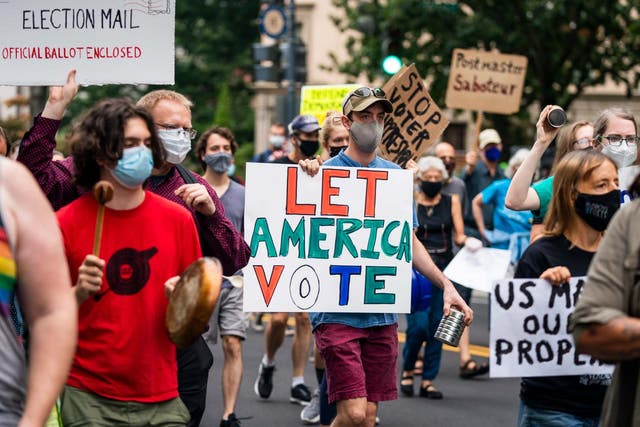 Protesters march to the apartment of Postmaster General Louis DeJoy in DC on 15 August. President Trump acknowledged he is blocking funds for the US Postal Service to make it more difficult for the agency to handle mail-in ballots for November's presidential election