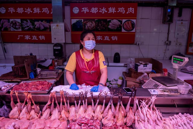 A vendor waits for customers at a chicken stall at a market in Beijing