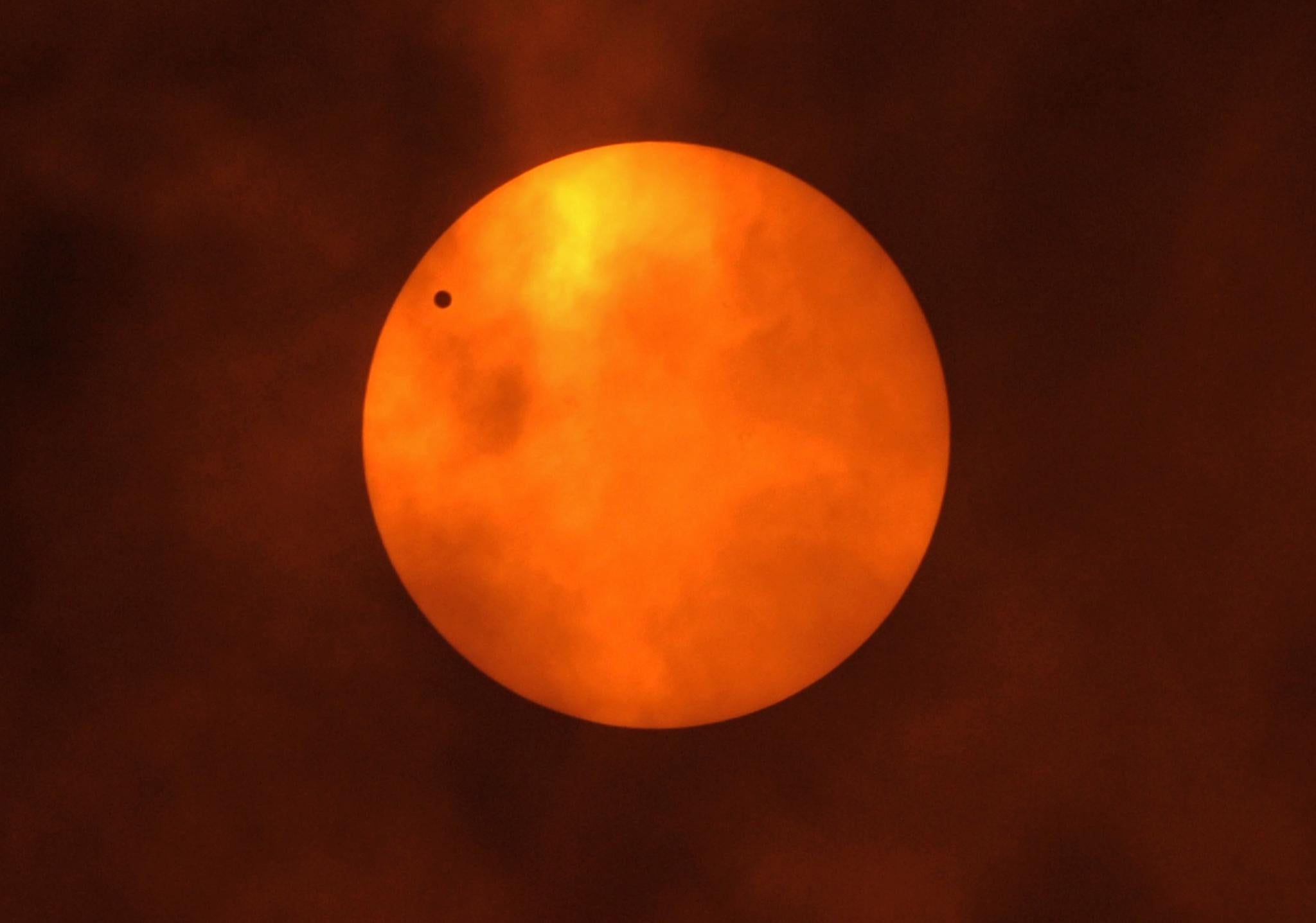 Venus (black dot) is silhouetted as it orbits between the Sun and the Earth during the transit of Venus