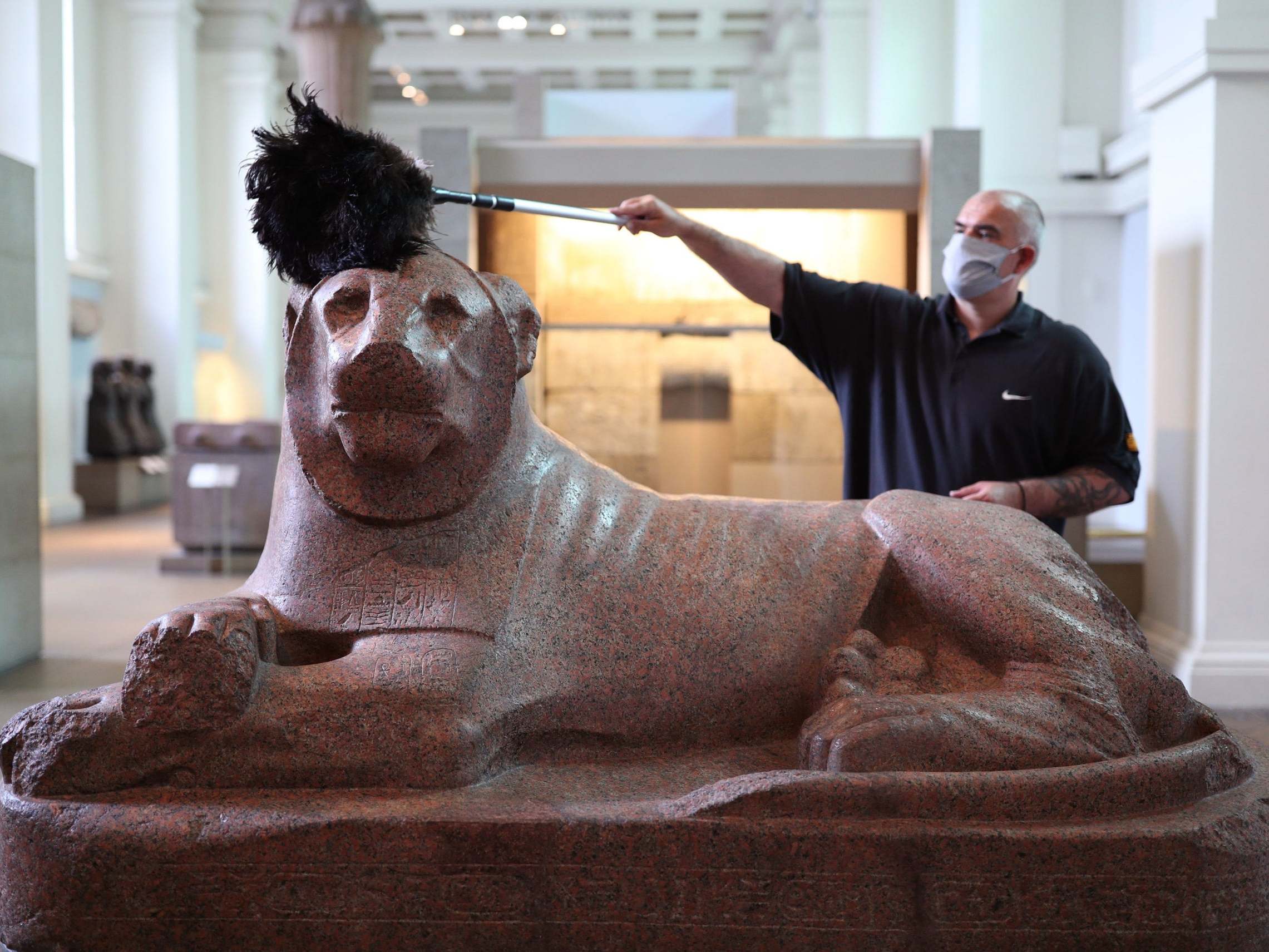 A sculpture of King Amenhotep III as a lion is cleaned in the museum’s Egyptian gallery
