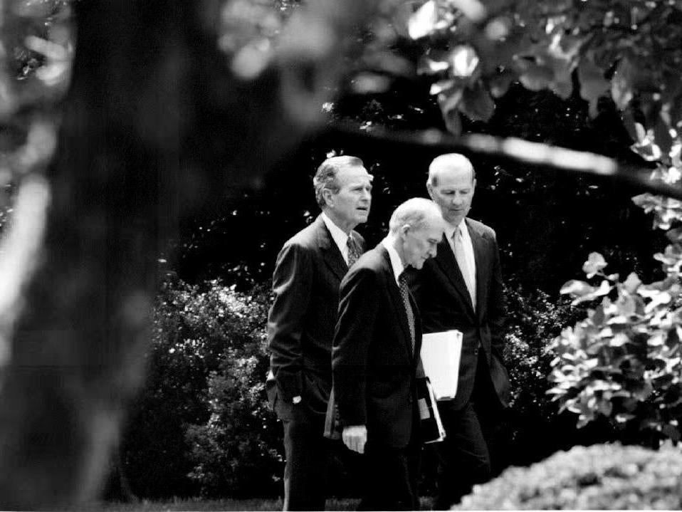 George HW Bush (left) speaks with Scowcroft (centre) and James Baker in 1992