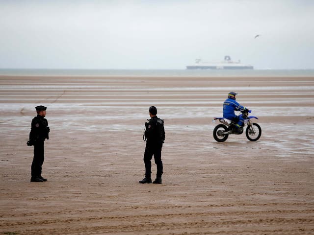 Police officers patrol on the beach of Oye-Plage, northern France, near Calais