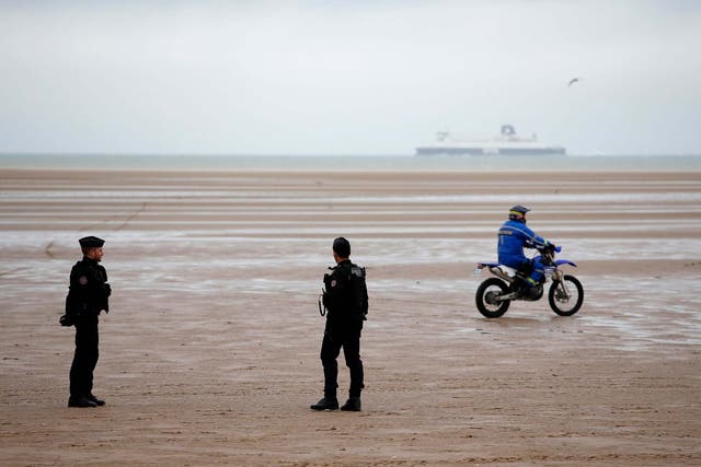 Police officers patrol on the beach of Oye-Plage, northern France, near Calais
