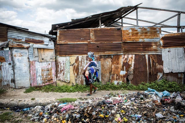 A woman scavenges for clothes in the rubbish mounds of La Saline slum in Port-au-Prince in July