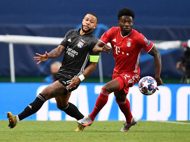 Olympique Lyonnais' Memphis Depay in action with Bayern Munich's Alphonso Davies