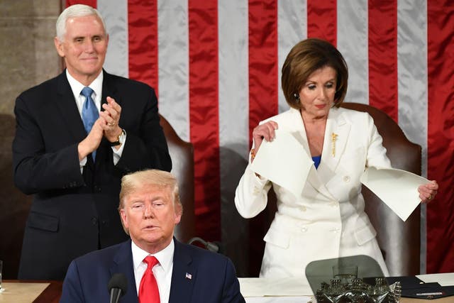 TOPSHOT - US Vice President Mike Pence claps as Speaker of the US House of Representatives Nancy Pelosi appears to rip a copy of US President Donald Trumps speech after he delivers the State of the Union address at the US Capitol in Washington, DC, on February 4, 2020.