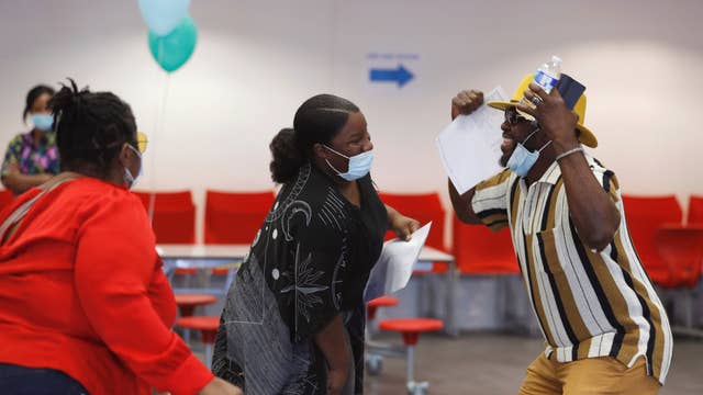 Parents and a student react after checking GCSE results at Ark Academy in London