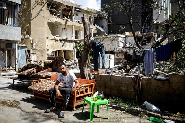 A Syrian refugee from Hama outside damaged buildings in the Karantina neighbourhood of Beirut, which lies directly off the ravaged port