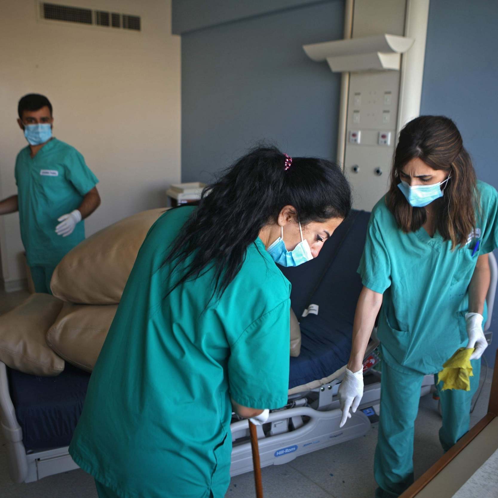 Nurses clean a damaged room in Saint George hospital, more than a week after the blast