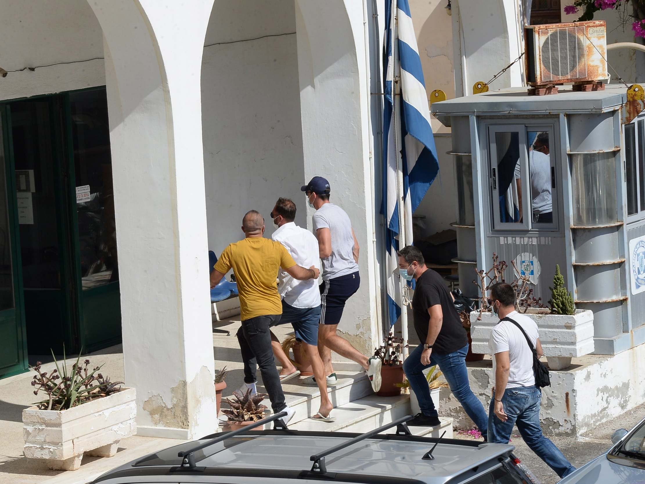 Manchester United captain Harry Maguire, wearing a cap, arrives at court in Syros, Greece