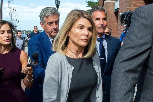 Lori Loughlin (centre) and her husband Mossimo Giannulli (right) exit the Boston federal courthouse on 27 August 2019.