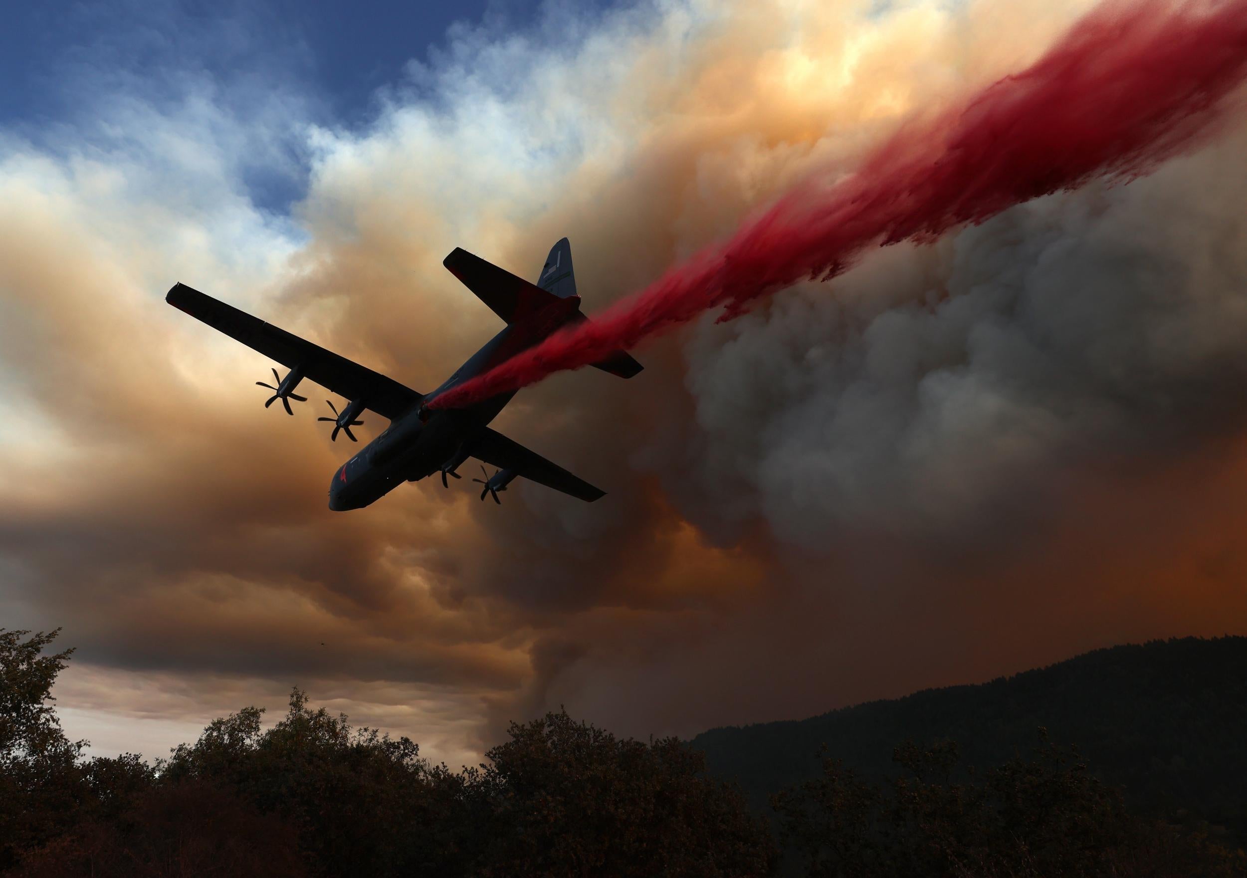 A Hercules C-130 aircraft drops retardant ahead of the LNU Lightning Complex fire earlier this week