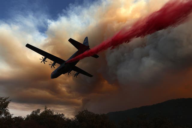 A Modular Airborne Fire Fighting Systems (MAFFS) equipped C-130 aircraft drops retardant ahead of the LNU Lightning Complex fire on August 20, 2020 in Healdsburg, California.
