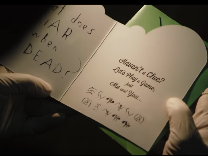 A still from The Batman trailer showing a clue sent by The Riddler