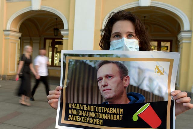 A woman holding a placard with an image of Navalny expresses support for the opposition leader
