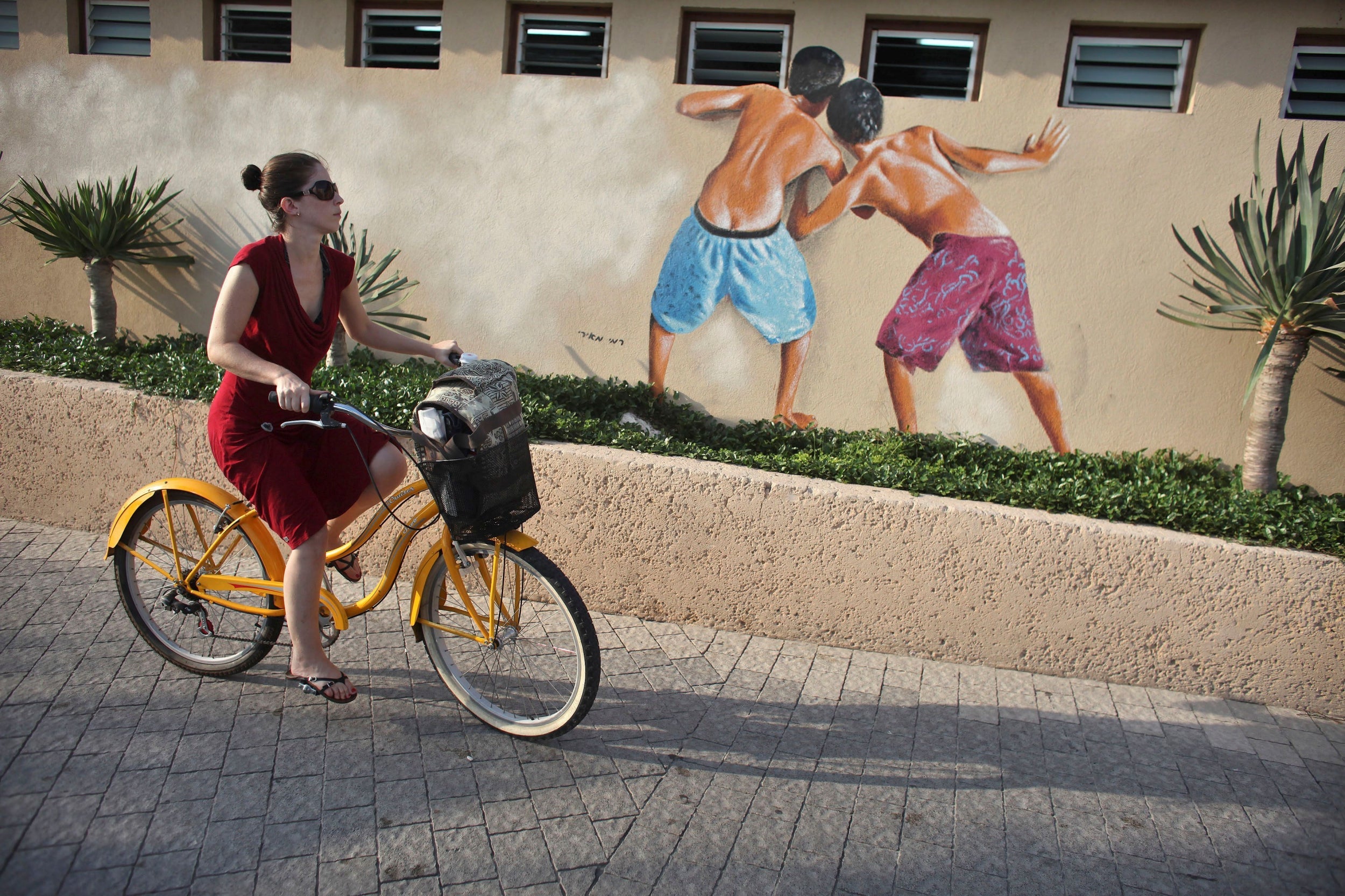 A woman cycles next to changing rooms as she leaves the beach on Thursday (Reuters)