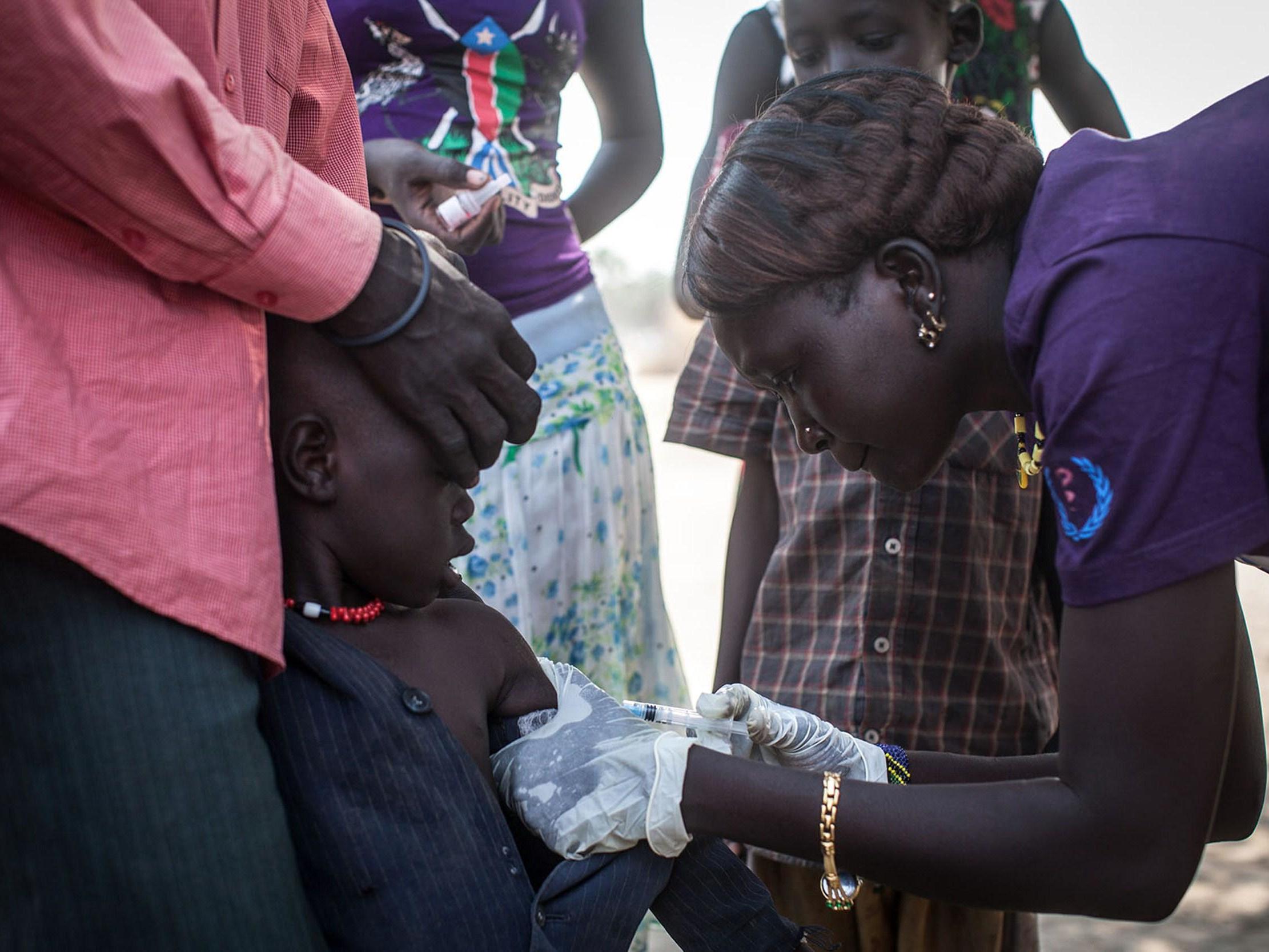 A member of Doctors Without Borders (MSF) administers polio vaccines to children in Minkammen, south Sudan