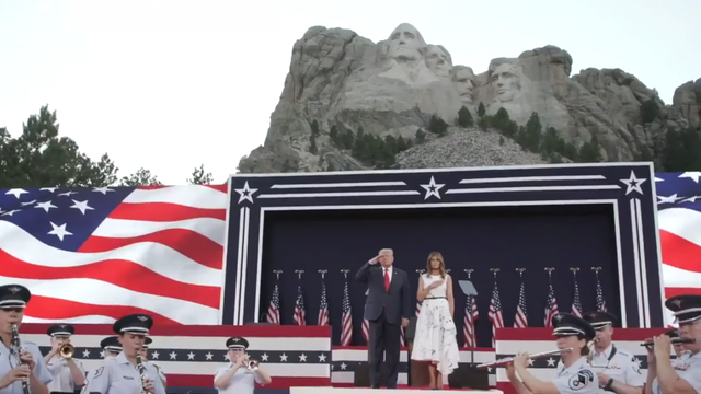 President Donald Trump and First Lady Melania Trump salute during the national anthem at a ceremony at Mount Rushmore in South Dakota.