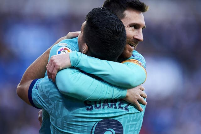 Luis Suarez of FC Barcelona celebrates with teammate Lionel Messi