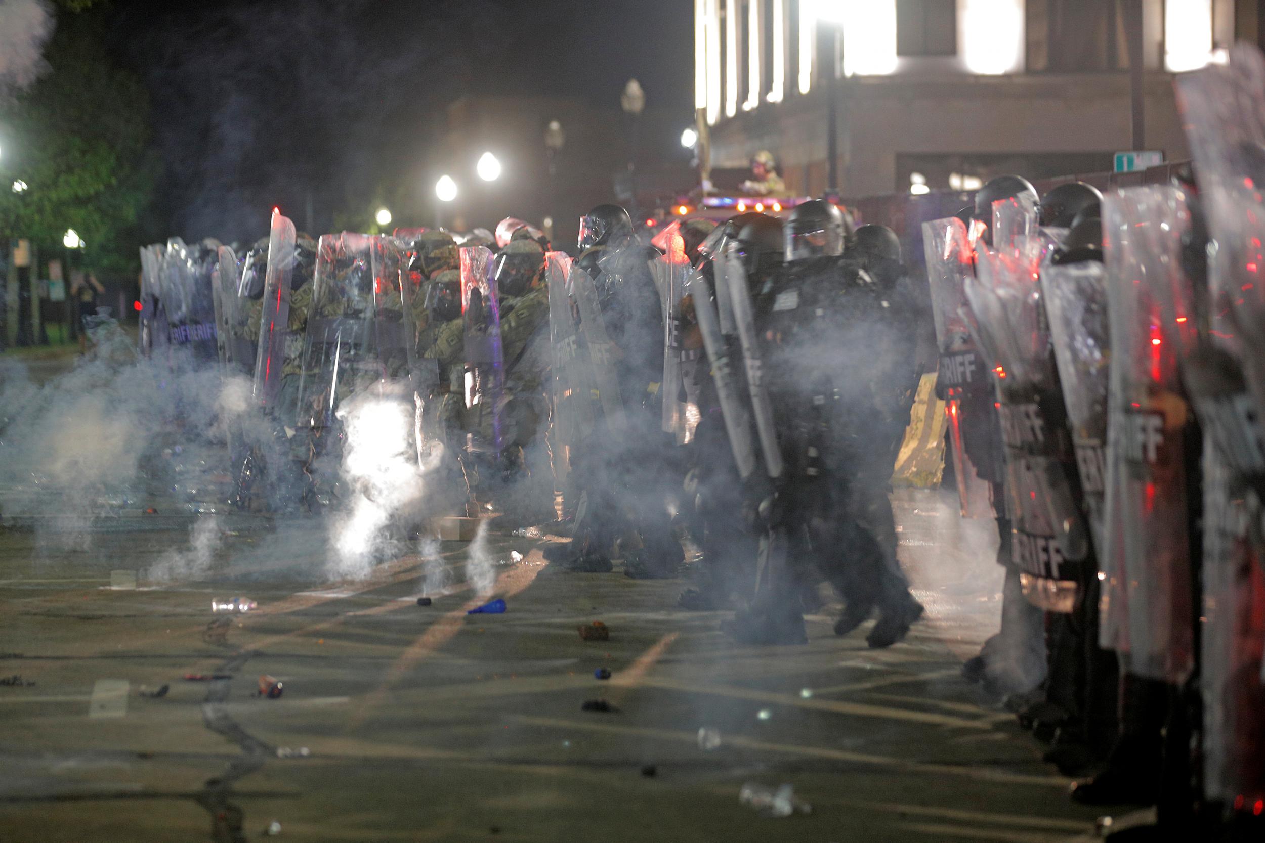 Law enforcement officers stand behind shields during a protest following the police shooting of Jacob Blake in Kenosha, Wisconsin on 25 August.