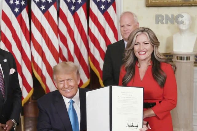 Jon Ponder (L), a convicted bank robber and founder of Hope for Prisoners, his wife Jamie Ponder and former FBI agent Richard Beasley look on as Donald Trump signs a document granting clemency to Ponder during the Republican National Convention