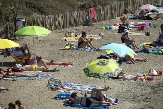 People bask in the sun at a beach in southern France on 11 August, 2020.