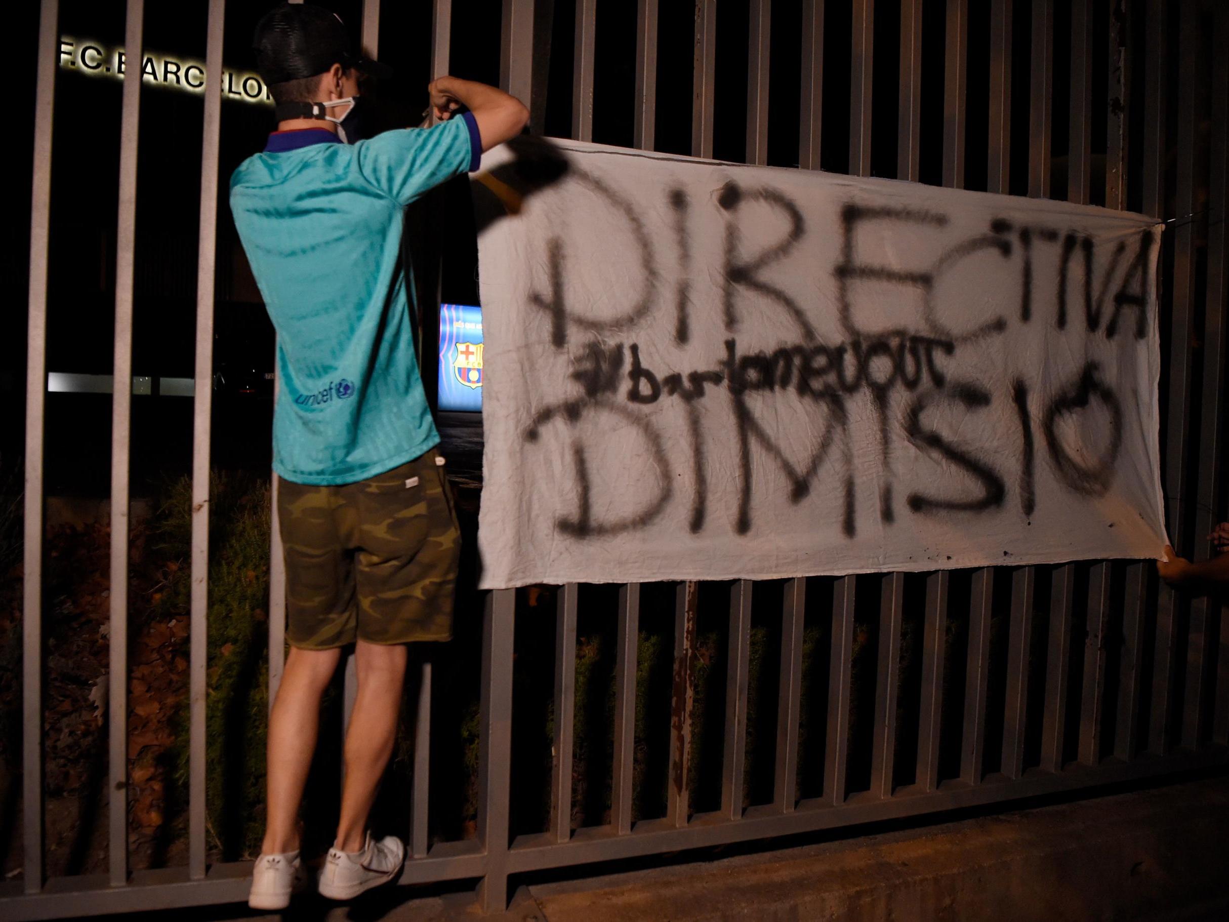 A Barca fan with a sign protesting the club’s board following Messi’s announcement